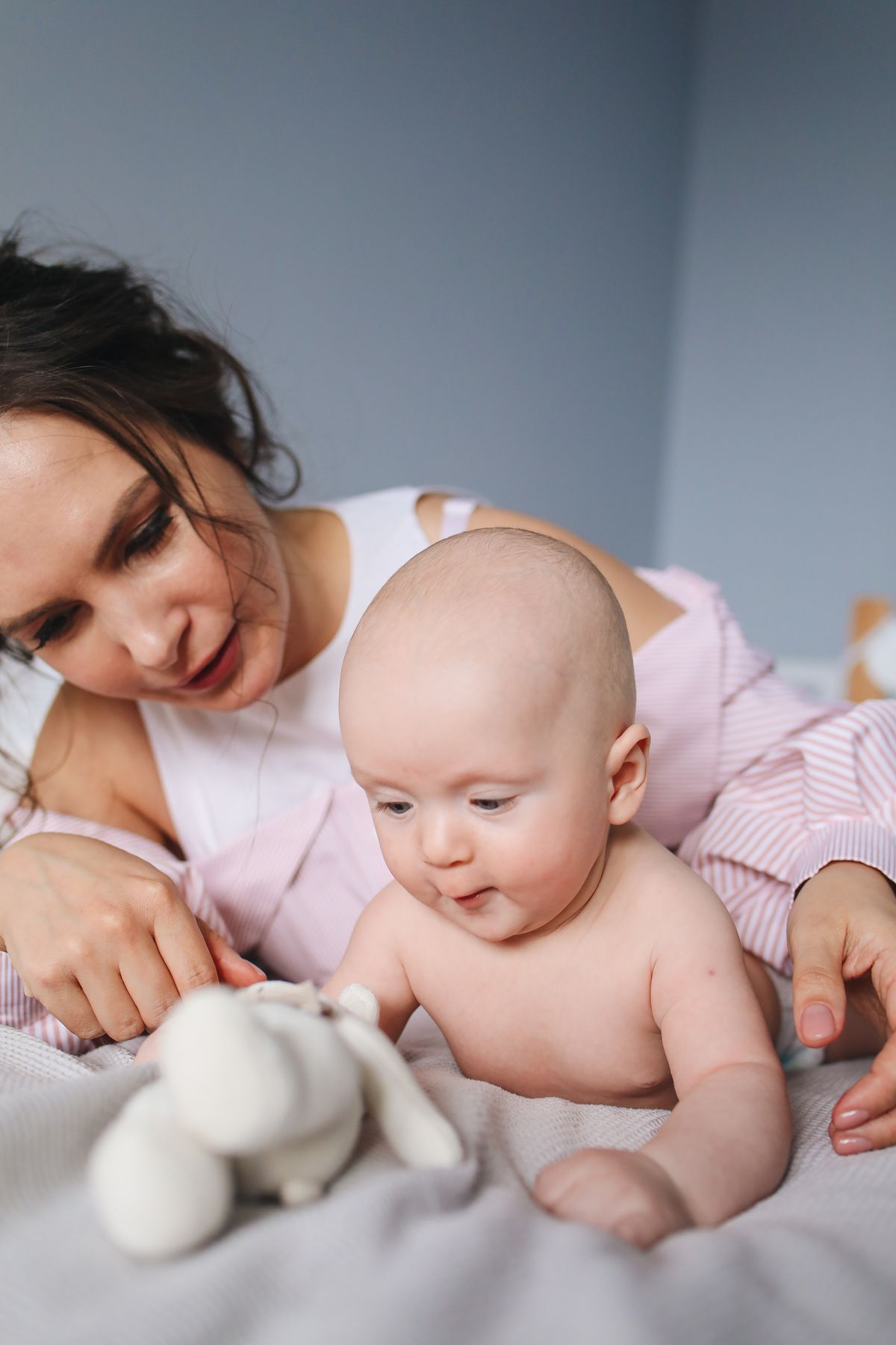 Mamma serena che gioca col suo bambino riposato